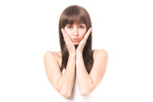 両手を頬にあてる女性